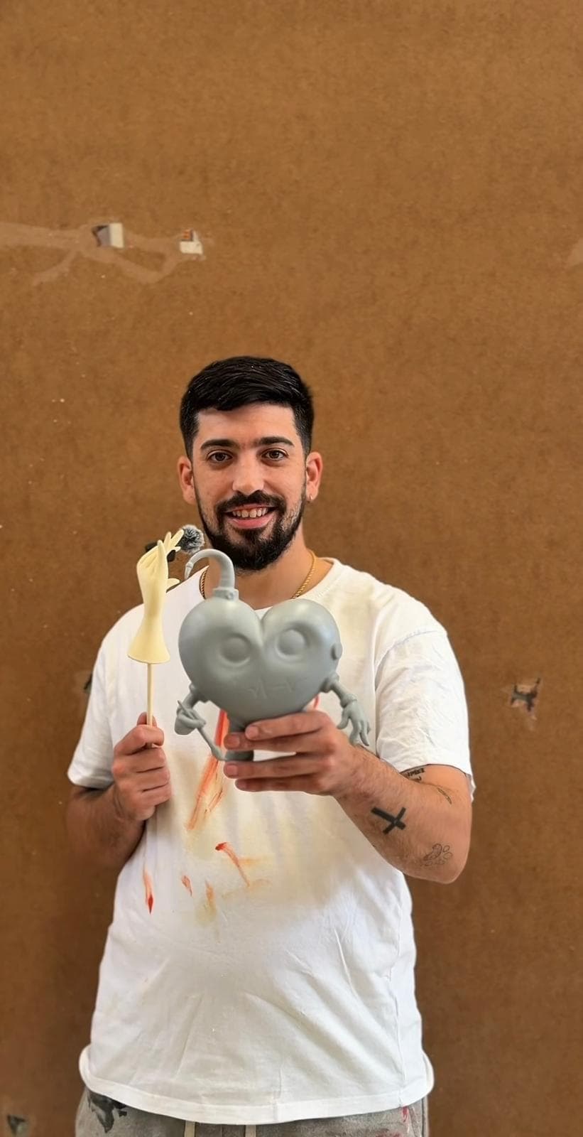 Adrián Alcaraz sostiene uno de los corazones antes de pintarlo